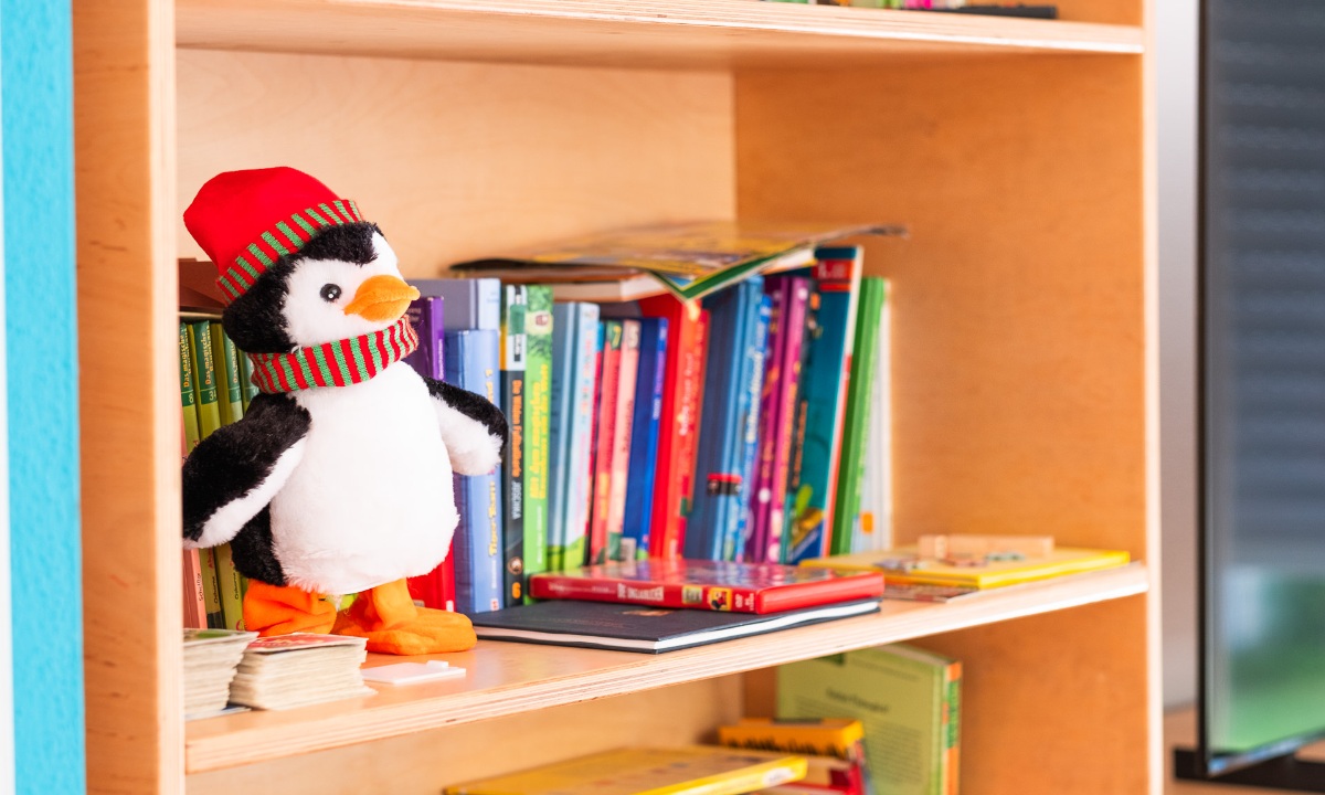 Pinguin-Plüschtier auf einem Bücherregal