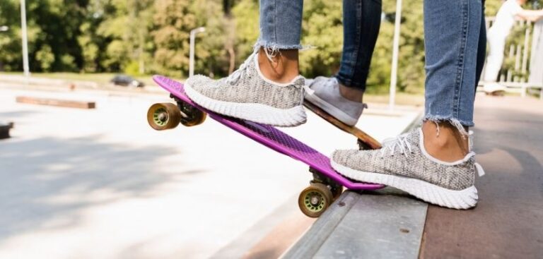 Zwei Personen mit Pennyboards auf einer Rampe. Das vordere Pennyboard ist pink
