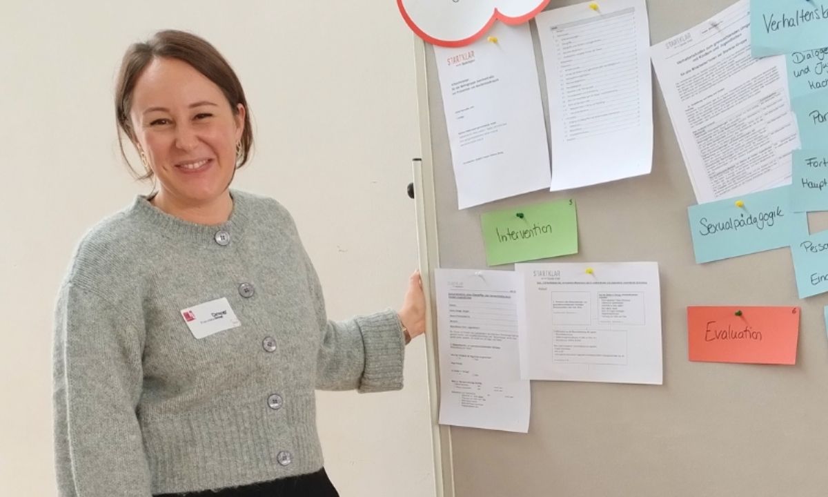 Eine Kollegin steht vor einer Pinnwand mit Begriffen aus der Sozialen Arbeit.
