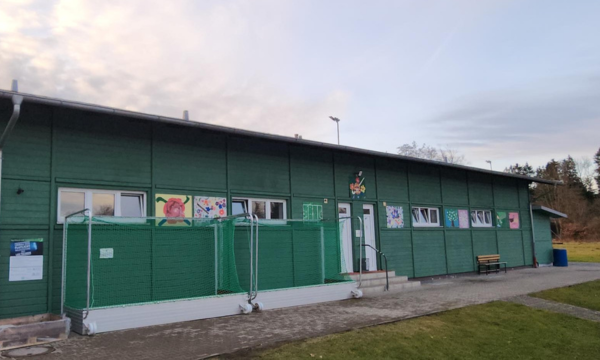 Sportkinderhaus Bilder Außenansicht des Sportkinderhauses Startklar in Rosenheim. Ein grünes Gebäude mit farbenfrohen Kinderbildern an der Außenfassade.